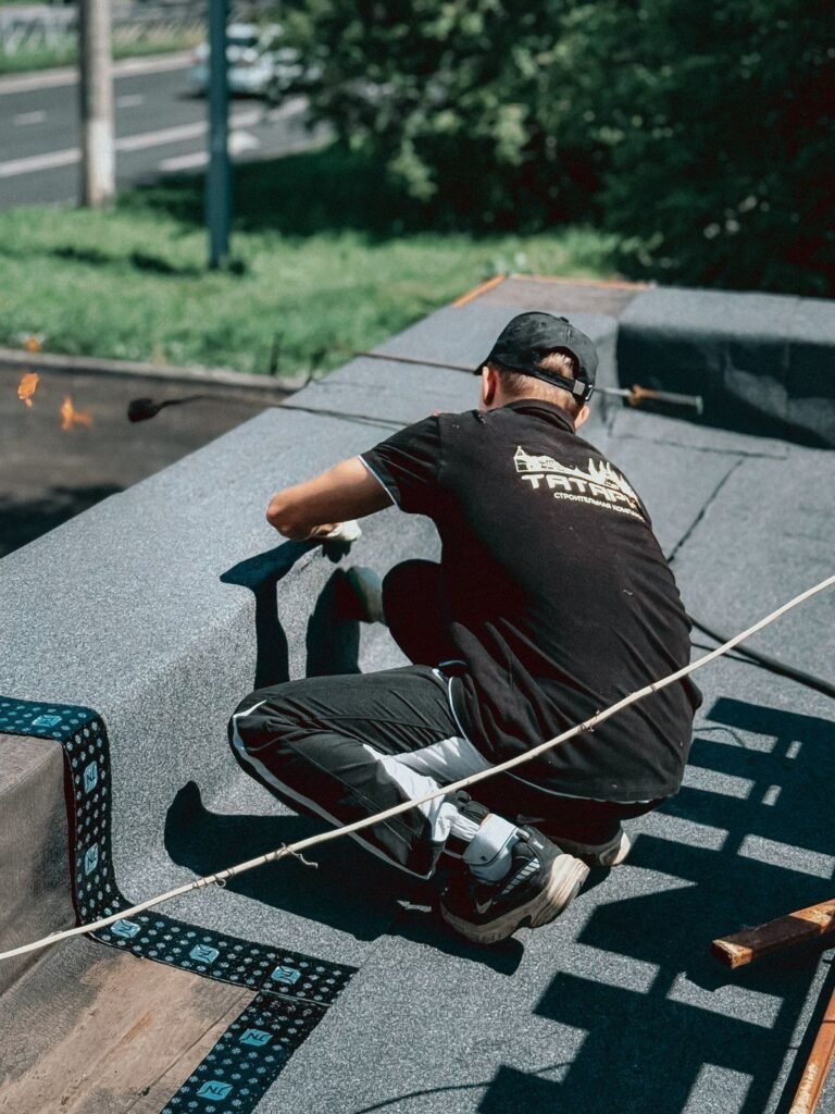 Roofer Working on a Flat Roof in Daylight — photographie d’illustration